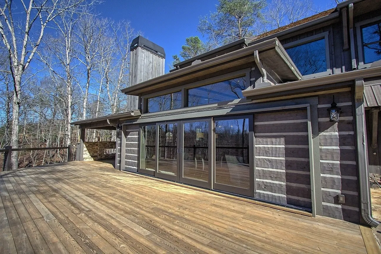 A large wooden deck with sliding glass doors.