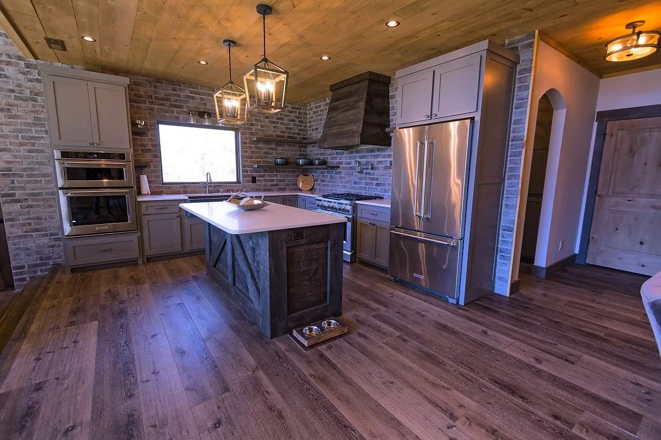 A kitchen with wood floors and stainless steel appliances.