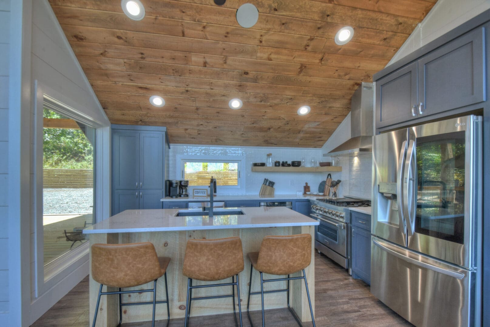 A kitchen in a tiny house with wood ceilings designed by Architectural Design services.