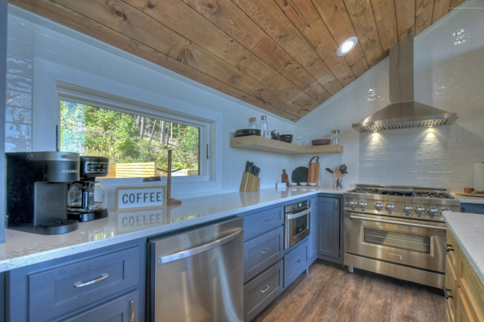 An architectural design services with a kitchen featuring blue cabinets and a wood ceiling.