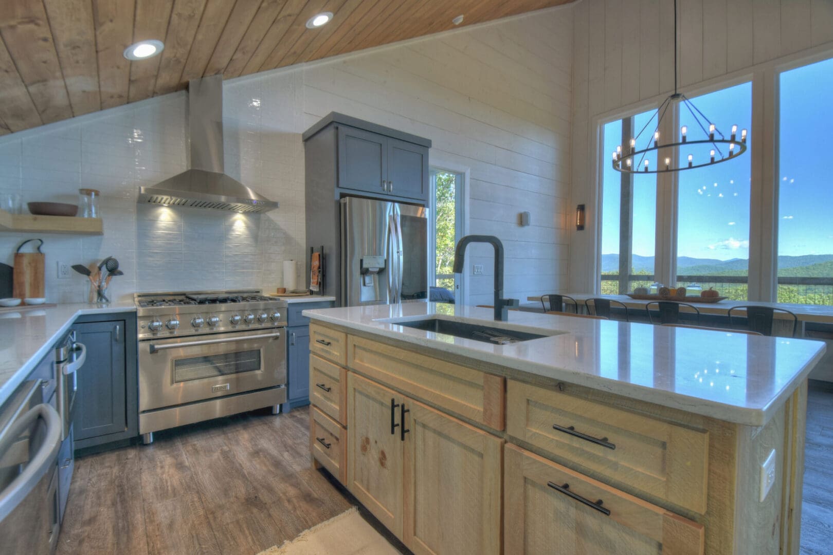 A kitchen with a wood ceiling and stainless steel appliances designed by Architectural Design services.
