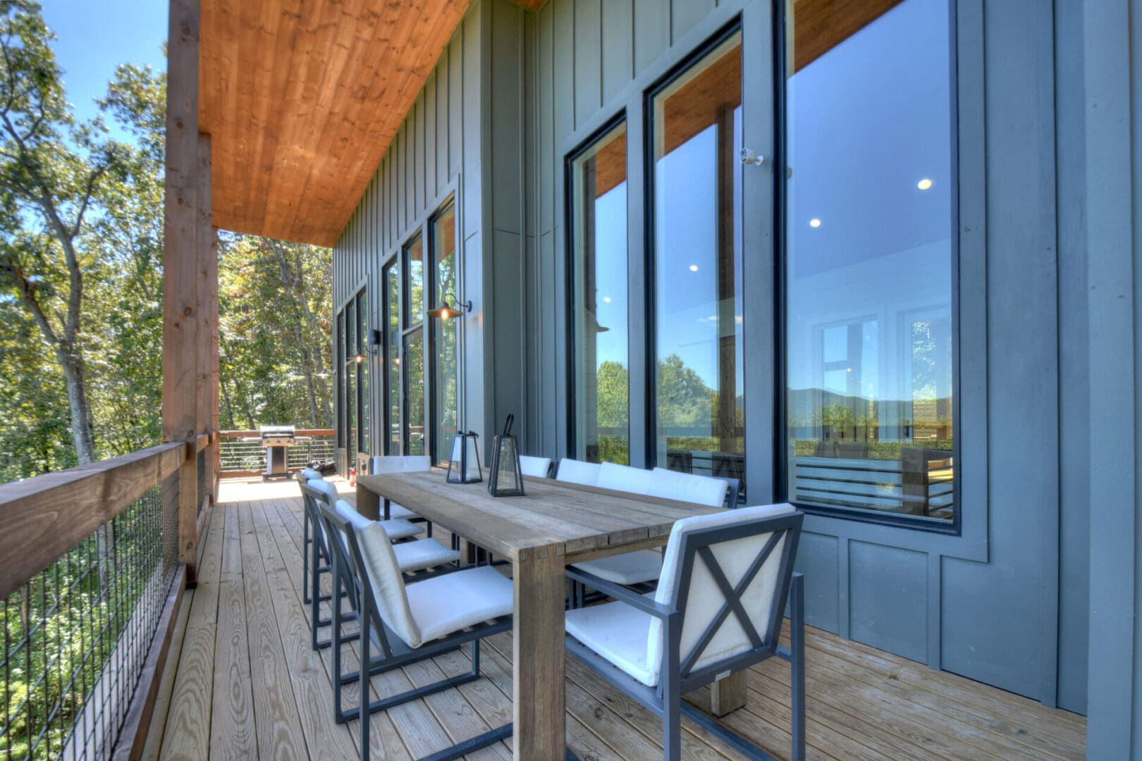 Architectural Design services: A deck with a table and chairs overlooking a wooded area, designed with expertise in architectural design services.