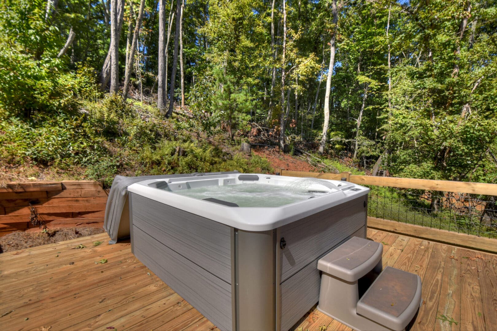 Architectural Design services: A luxurious hot tub beautifully placed on a deck amidst the serene woods.
